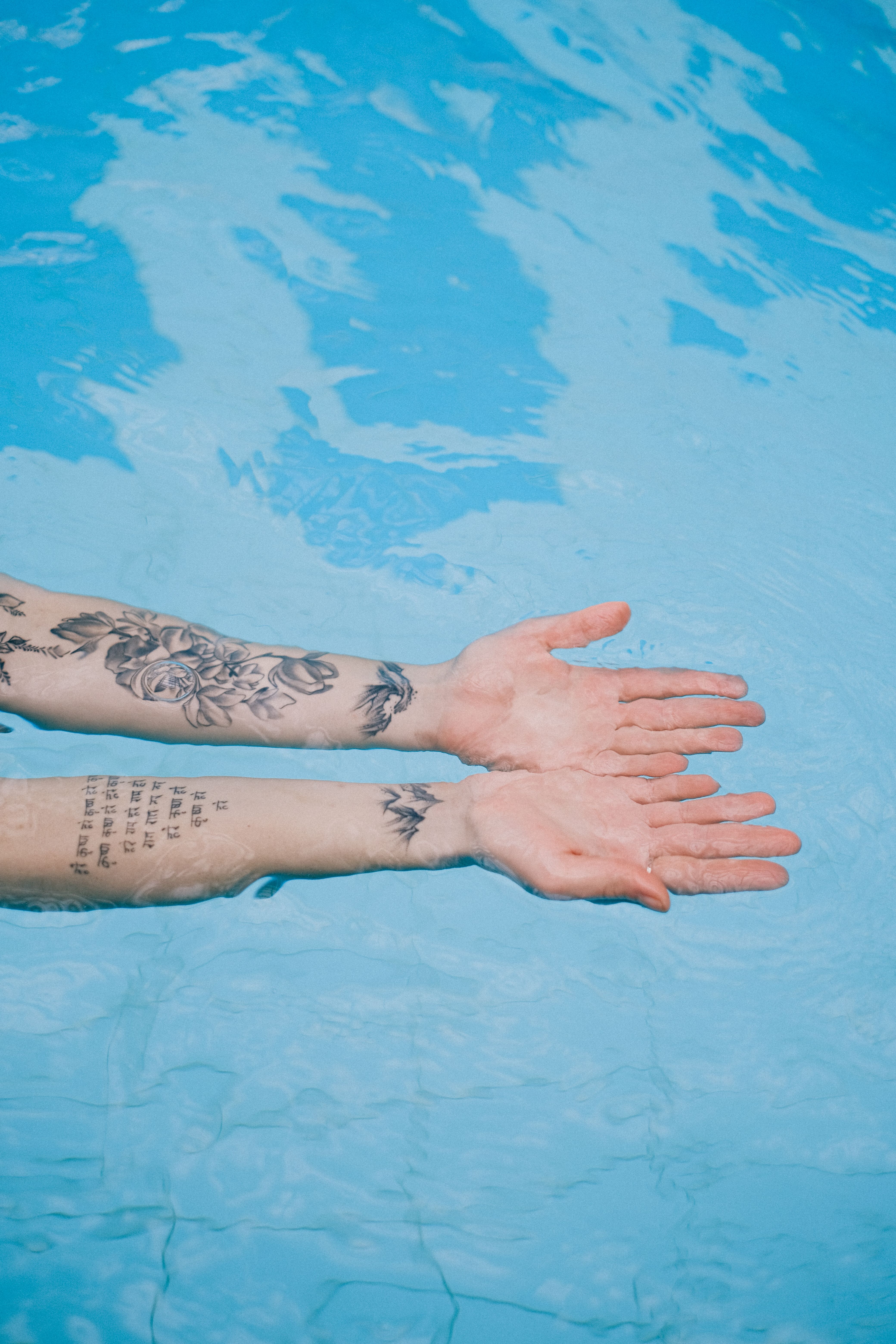 Mulher na piscina com tatuagem já cicatrizada — diferença visual clara